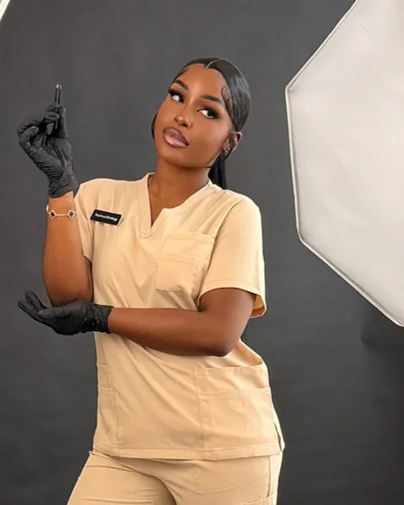 The Face Strategy practitioner in a beige uniform and black gloves, in the studio